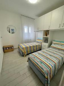 2 camas en una habitación con armarios blancos en Stelle Marine, en Tropea 32 fotos más