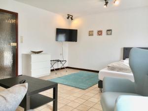 - un salon avec un lit et une télévision murale dans l'établissement Townus Apartments Heidenrod, à Zorn