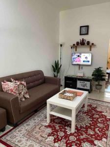 a living room with a couch and a coffee table at Rose Homestay in Sitiawan