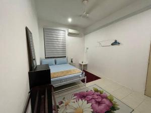 a bedroom with a bed and a window with flowers on the floor at Rose Homestay in Sitiawan