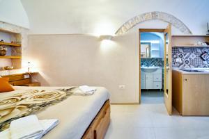 1 dormitorio con 1 cama y baño con lavamanos en Casetta Lulù, en Ostuni
