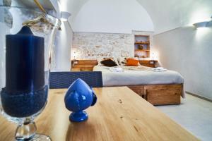1 dormitorio con cama y mesa con copa de vino en Casetta Lulù, en Ostuni