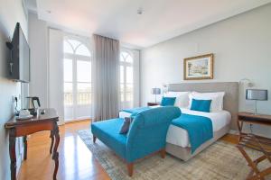 Villa Bela Vista في سينترا: غرفة نوم بسرير كبير وكرسي ازرق
