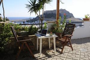 a table and two chairs with a laptop on it at Chrysa Studios in Lindos