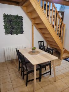 una mesa de madera y sillas en una habitación con escalera en Proche Chambord La petite maison, en Thoury