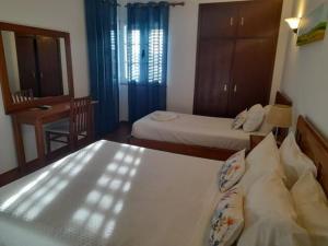 1 dormitorio con 2 camas, mesa y espejo en Terras de Monsaraz, en Reguengos de Monsaraz