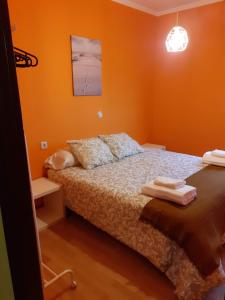 1 dormitorio con 1 cama con paredes de color naranja en Praia da Borna 1ºB, en Pontevedra