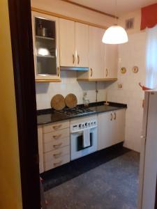 Una pequeña cocina con estufa y microondas. en Praia da Borna 1ºB, en Pontevedra