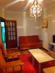 sala de estar con sofá, mesa y lámpara de araña en Praia da Borna 1ºB, en Pontevedra