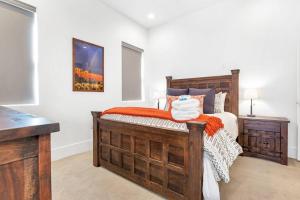 a bedroom with a wooden bed with an orange blanket at Villa 13, 4 BEDROOM NEW LISTING! STUNNING! YEAR ROUND HEATED POOL & HOT TUB! in St. George