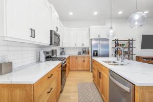 a kitchen with white appliances and wooden cabinets at Villa 13, 4 BEDROOM NEW LISTING! STUNNING! YEAR ROUND HEATED POOL & HOT TUB! in St. George
