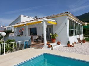 uma casa com uma piscina em frente em B&B Buena Vista em Alhaurín el Grande