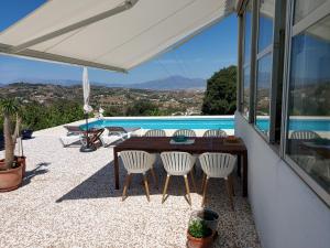 a patio with a table and chairs and a pool at B&B Buena Vista in Alhaurín el Grande