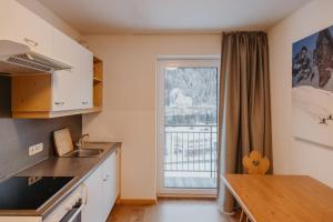 a kitchen with a table and a large window at Gästehaus Kolp in Sankt Anton am Arlberg