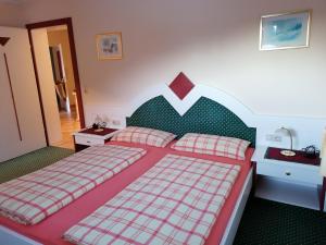 a bedroom with a large bed with a red and white headboard at Haus Bielefeld in Elmen