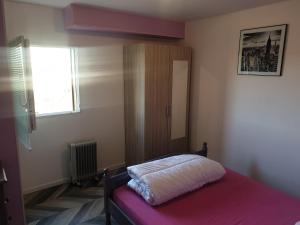 Un dormitorio con una cama y un armario y una ventana. en Le Blarsois, en Blars