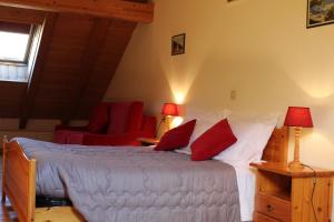 a bedroom with a large bed with red pillows at Residenze Sonnenschein Casa Rossa in Villabassa