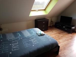 Un dormitorio con una cama con escritura. en Charmante chambre d'hôtes en Normandie, en Valognes