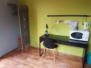 Cette chambre comprend un bureau avec un four micro-ondes et une chaise. dans l'établissement Charmante chambre d'hôtes en Normandie, à Valognes