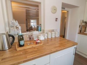 a kitchen counter with a bottle of wine and glasses at Kirrin Cottage in Conwy