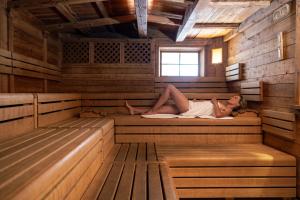 a woman laying in the inside of a sauna at Tevini Dolomites Charming Hotel in Commezzadura