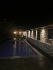 ein Schwimmbad in der Nacht mit Lichtern an einem Gebäude in der Unterkunft Gite Au Coeur de Han in Han-sur-Lesse