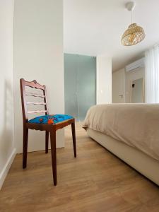 una sedia seduta in una camera da letto accanto a un letto di Casa Sousa - 3rd generation (Apart.2) a Boticas