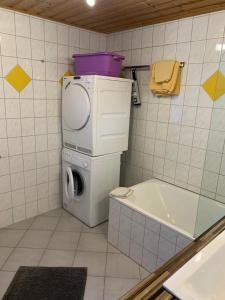 a bathroom with a washing machine and a tub at Landhaus Alpenstern in Riezlern