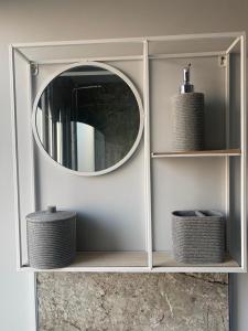 a mirror in a white cabinet with wicker baskets at Town Centre Holiday Let in Hawick