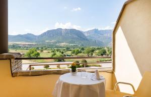 una mesa con vistas a las montañas desde una ventana en Hotel Restaurant Cal Petit, en Oliana