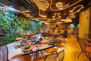 a restaurant with tables and chairs and plants at Hotel V1501 in Pasto