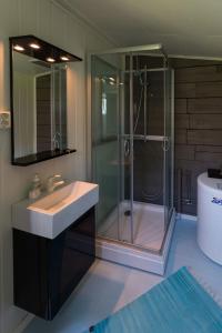 a bathroom with a glass shower and a sink at Cozy cabin with stunning view in Alstad