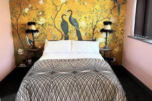 una camera da letto con un letto e carta da parati a forma di uccello di Lovely independent 1-Bed Apartment in Freshwater a Freshwater