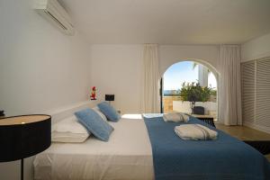 a bedroom with a large bed with blue and white pillows at VERTIGO- Managed by Almarina in Benissa