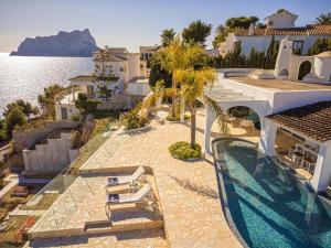 ein Haus mit einem Swimmingpool direkt am Wasser in der Unterkunft VERTIGO- Managed by Almarina in Benissa