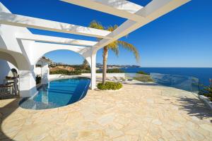 ein weißes Haus mit einem Pool und einer Pergola in der Unterkunft VERTIGO- Managed by Almarina in Benissa