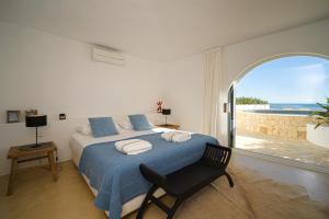 a bedroom with a bed and a chair and a window at VERTIGO- Managed by Almarina in Benissa