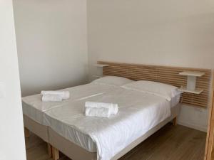 uma cama branca com duas toalhas em cima em RESIDENCE BLUMAR 2 em Lido di Jesolo