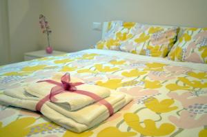 a bed with a towel with a bow on it at Midway House Italy in Sant'Egidio del Monte Albino