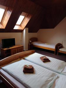 a bedroom with two beds and a tv and windows at Penzion Stella in Luhačovice