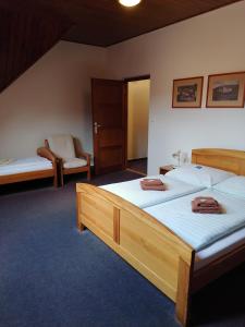 a hotel room with two beds and a chair at Penzion Stella in Luhačovice