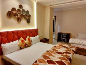 a bedroom with a large bed with an orange headboard at Hotel Luxuria in Ludhiana