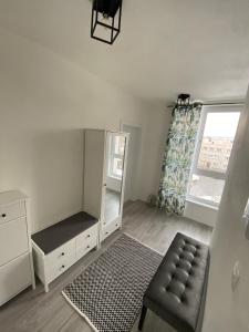 um quarto com uma cómoda, uma cadeira e uma janela em GNG Apartment em Košice