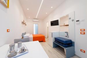 聖貝內代托德爾特龍托的住宿－La Retara Affittacamere，一间设有一张床的白色客房和一间带桌子的房间