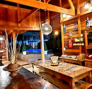イタポアにあるSPA Rossett em Itapoá - Luxo e conforto c piscina, hidromassagem e cromoterapia, p 22 pessoas!の木製テーブル付きの客室で、