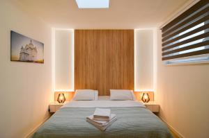 ein Schlafzimmer mit einem Bett mit zwei Lampen und einem Fenster in der Unterkunft Apartmán Astrid 4 in Mikulov