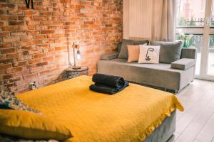 a living room with two beds and a brick wall at Silver box in Gdańsk