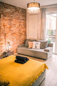 a living room with a couch and a brick wall at Silver box in Gdańsk