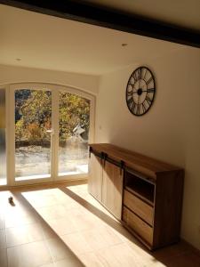 a living room with a clock on the wall at Studio de Charme neuf à la Montagne in Puget-Rostang