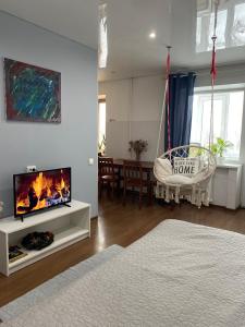 een woonkamer met een tv en een woonkamer met een open haard bij ART apartment in Zhytomyr